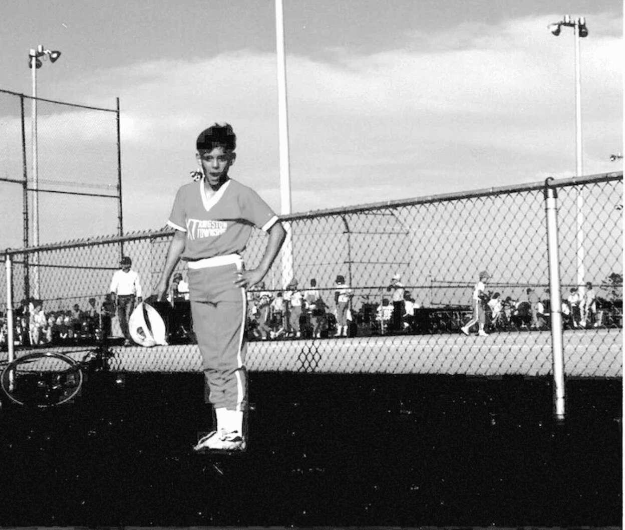A young baseball player standing beside a ball field in 1995
